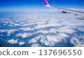 Plane wing glides above fluffy white clouds 137696550