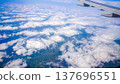 Plane wing glides above fluffy white clouds 137696551