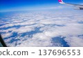 Plane wing glides above fluffy white clouds 137696553