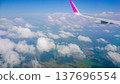 Plane wing glides above fluffy white clouds 137696554