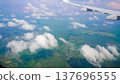 Plane wing glides above fluffy white clouds 137696555