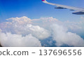 Plane wing glides above fluffy white clouds 137696556