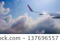 Plane wing glides above fluffy white clouds 137696557