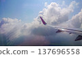 Plane wing glides above fluffy white clouds 137696558