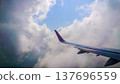 Plane wing glides above fluffy white clouds 137696559
