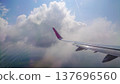 Plane wing glides above fluffy white clouds 137696560