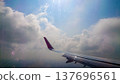 Plane wing glides above fluffy white clouds 137696561