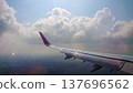 Plane wing glides above fluffy white clouds 137696562