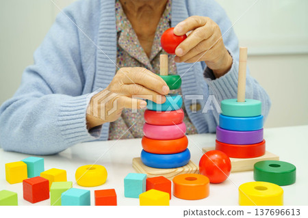 Asian elderly woman playing enhancing skill board game. Asian elderly woman playing enhancing skill board game. 137696613