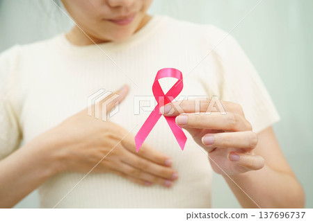 Asian woman with pink ribbon for October world breast cancer day. Asian woman with pink ribbon for October world breast cancer day. 137696737