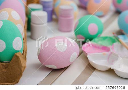 many colorful pastel decorated easter eggs and watercolor painting tool on table 137697026