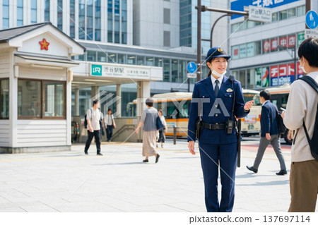 一名警察在車站前指揮交通——這是日常景象，有助於保障行人和城市的安全。 137697114
