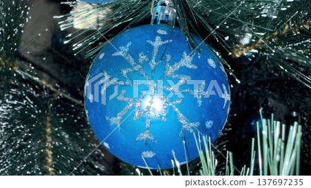 glittery blue snowflake christmas bauble on pine branch for holiday web design glittery blue snowflake christmas bauble on pine branch for holiday web design 137697235