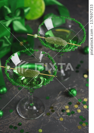 Green Cocktails with Lime,  Gifts and Confetti. Festive St. Patricks Day Celebration Still Life 137697333