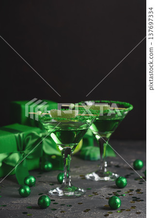 Green Cocktails with Lime,  Gifts and Confetti. Festive St. Patricks Day Celebration Still Life 137697334