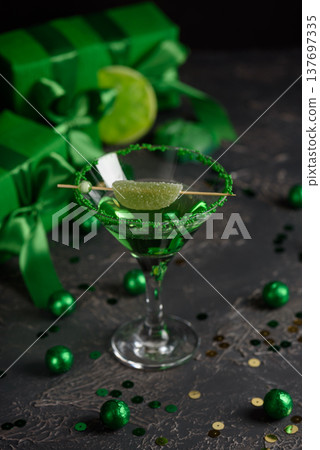 Green Cocktails with Lime,  Gifts and Confetti. Festive St. Patricks Day Celebration Still Life 137697335