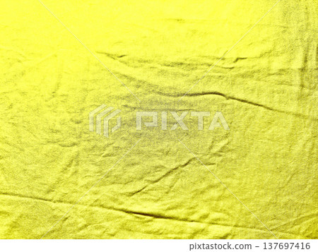 vibrant yellow fabric wrinkled with central dark stain evoking subtle mystery perfect for abstract texture background or web banner copy space vibrant yellow fabric wrinkled with central dark stain evoking subtle mystery perfect for abstract texture background or web banner copy space 137697416