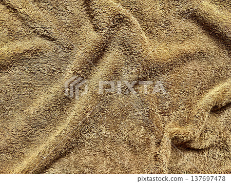 lush golden brown terrycloth texture folds softly in closeup evoking cozy warmth for autumn wallpaper or neutral commercial background lush golden brown terrycloth texture folds softly in closeup evoking cozy warmth for autumn wallpaper or neutral commercial background 137697478