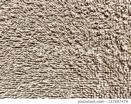 closeup fluffy beige terry cloth texture with looped fibers and warm earth tones for spa wallpaper or cozy banner background 137697479