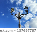 An old streetlamp stands out against the cloudy sky of an Italian city. 137697767