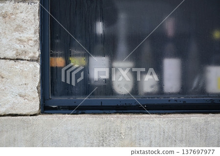 A modern architectural landscape with condensation-covered windowpanes and stone walls. A modern architectural landscape with condensation-covered windowpanes and stone walls. 137697977