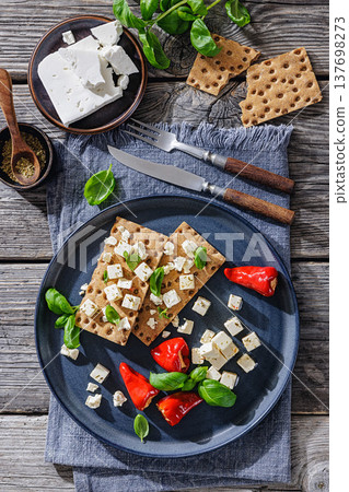 Rye crispbread open sandwich with feta and peppers 137698273