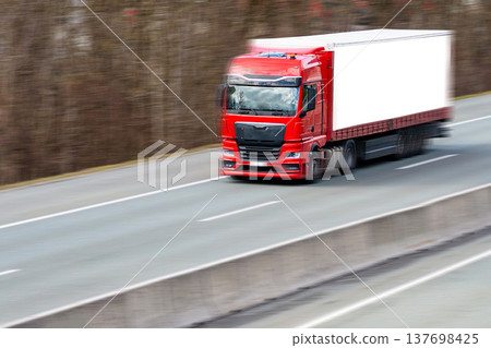 Red semi truck transporting goods on highway asphalt Red semi truck transporting goods on highway asphalt 137698425