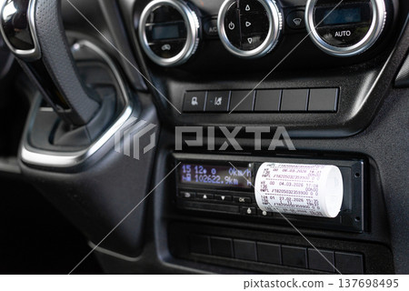 Driver inserting card into digital tachograph for log record 137698495