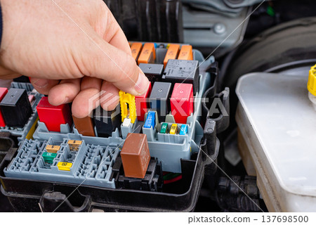 Open automotive fuse box with colorful electrical relays Open automotive fuse box with colorful electrical relays 137698500