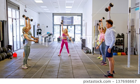 Group of people training with dumbbells in a gym 137698667