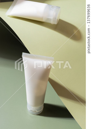 Minimal cosmetic skincare tubes on geometric pastel background with sunlight and shadows, beauty product packaging concept 137699636