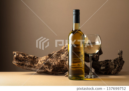 White wine and old snag on a beige background. White wine and old snag on a beige background. 137699752
