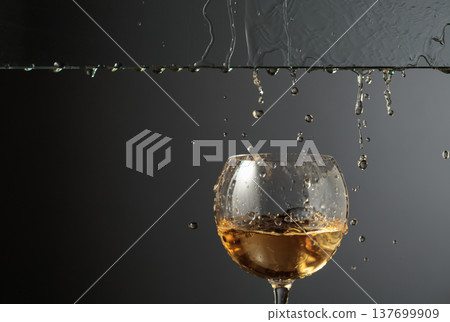 White wine flows down into a glass. White wine flows down into a glass. 137699909