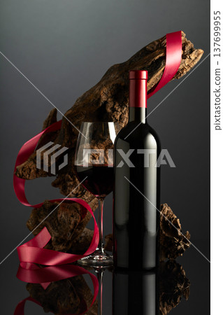 Bottle and glass of red wine on a black reflective background. Bottle and glass of red wine on a black reflective background. 137699955