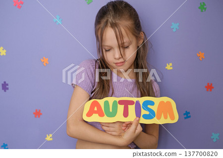 A kind, modest autistic girl holds a sign with the inscription autism calling for support for people with autism spectrum disorder A kind, modest autistic girl holds a sign with the inscription autism calling for support for people with autism spectrum disorder 137700820
