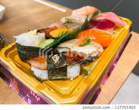 Nigiri sushi served in a plastic container. Includes conger eel, white shrimp, and sea urchin. Nigiri sushi served in a plastic container. Includes conger eel, white shrimp, and sea urchin. 137701403
