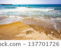 The letters written in the sand are washed away by the waves. 137701726