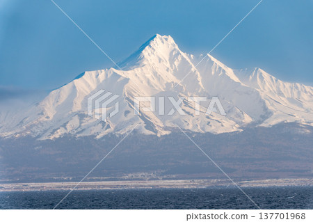 從海上眺望白雪皚皚的利尻山,冬日美景盡收眼底。 從海上眺望白雪皚皚的利尻山,冬日美景盡收眼底。 137701968
