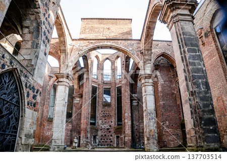 Interior view of Alt St. Alban, a historic church in Cologne, Germany. The structure features tall arches, brick walls, and remnants of stained glass windows. Interior view of Alt St. Alban, a historic church in Cologne, Germany. The structure features tall arches, brick walls, and remnants of stained glass windows. 137703514