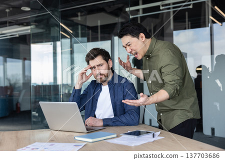 Upset employee experiencing stress and frustration from an angry boss or toxic coworker shouting and expressing anger during a difficult office argument and conflict 137703686