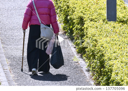 An elderly woman with a cane (wearing a mask) in Yokohama, Japan; an aging society... what is life...? = Yokohama City 137705096