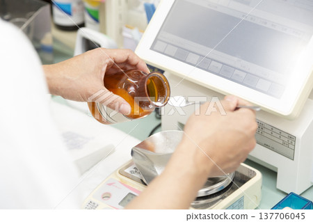 A scene from a pharmacy or hospital where medications are accurately weighed using an electronic balance. A scene from a pharmacy or hospital where medications are accurately weighed using an electronic balance. 137706045