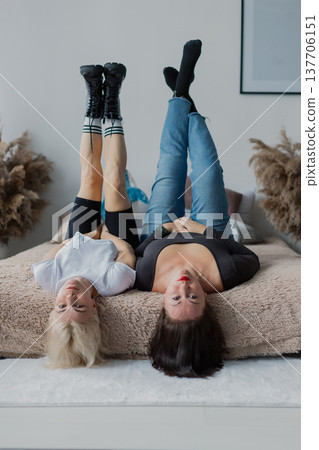 Two beautiful women posing on the bed 137706151