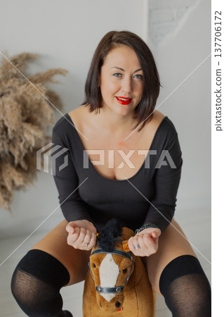 Beautiful woman posing for photographer near wall Beautiful woman posing for photographer near wall 137706172