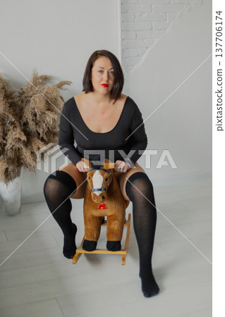 Beautiful woman posing for photographer near wall Beautiful woman posing for photographer near wall 137706174