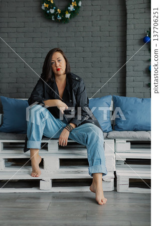 Woman posing for camera in photo studio on wooden Woman posing for camera in photo studio on wooden 137706251
