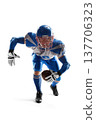 NFL. American Football. A young, agile American football player holding the ball. Football defense. Sports emotions. Athlete in action 137706323