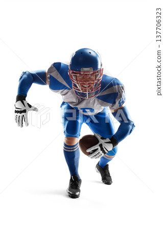 NFL. American Football. A young, agile American football player holding the ball. Football defense. Sports emotions. Athlete in action NFL. American Football. A young, agile American football player holding the ball. Football defense. Sports emotions. Athlete in action 137706323