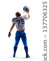 Football. NFL. Football player holding the helmet in his hand. Sport emotions. Sport victory. Joy in football. Back view. Isolated 137706325