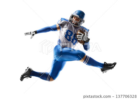 American football player in action. American football player catches the ball and jumps in the air. Athlete in action. Isolated image on white background American football player in action. American football player catches the ball and jumps in the air. Athlete in action. Isolated image on white background 137706328